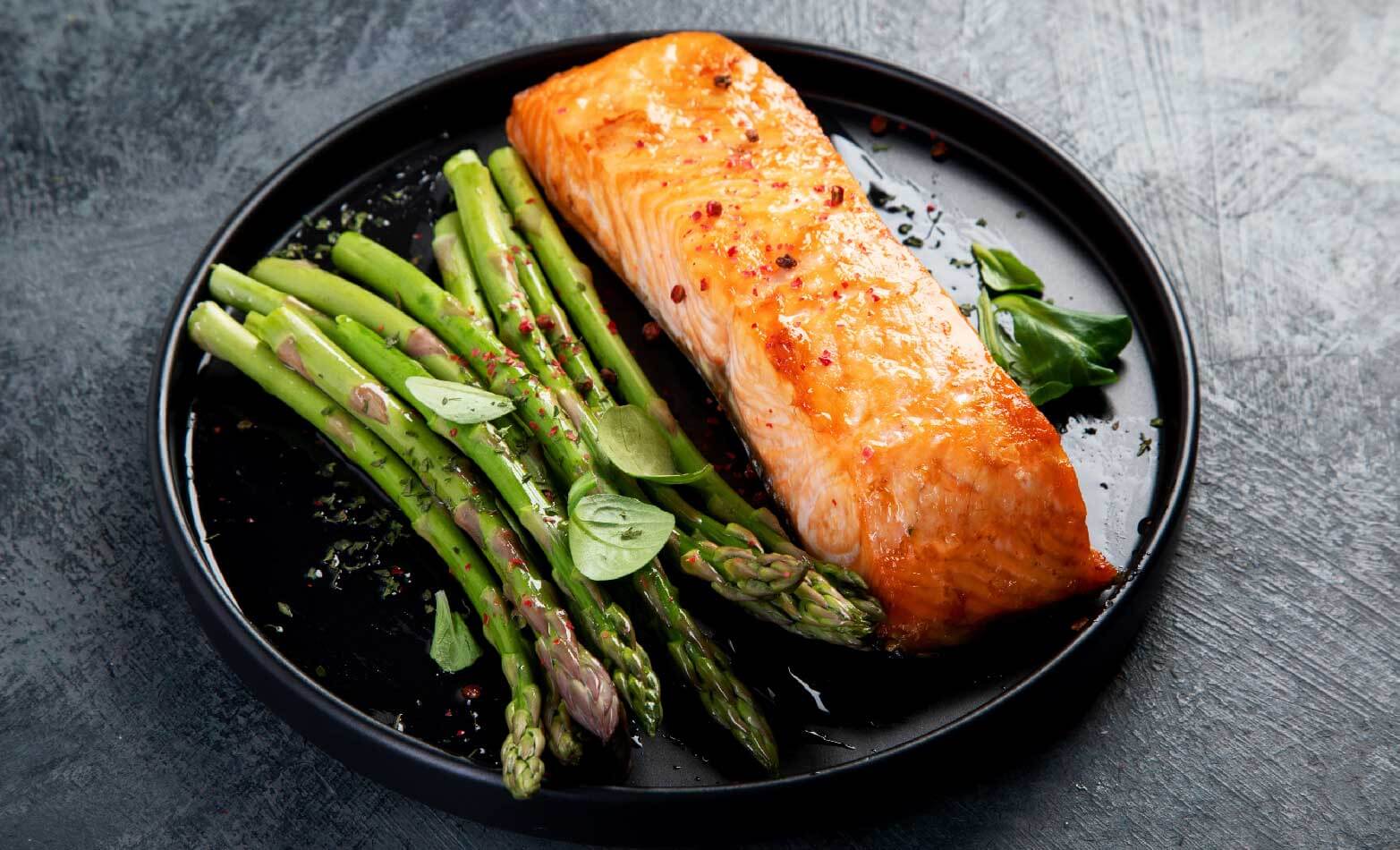 a stock photo of baked salmon and asparagus