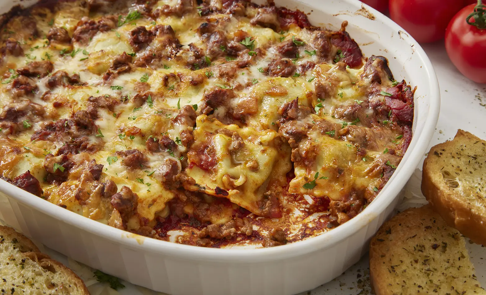 Baked lasagna with ravioli in a white baking dish