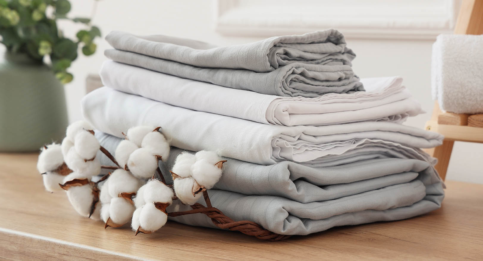 A photo of a stack of folded grey bedsheets.