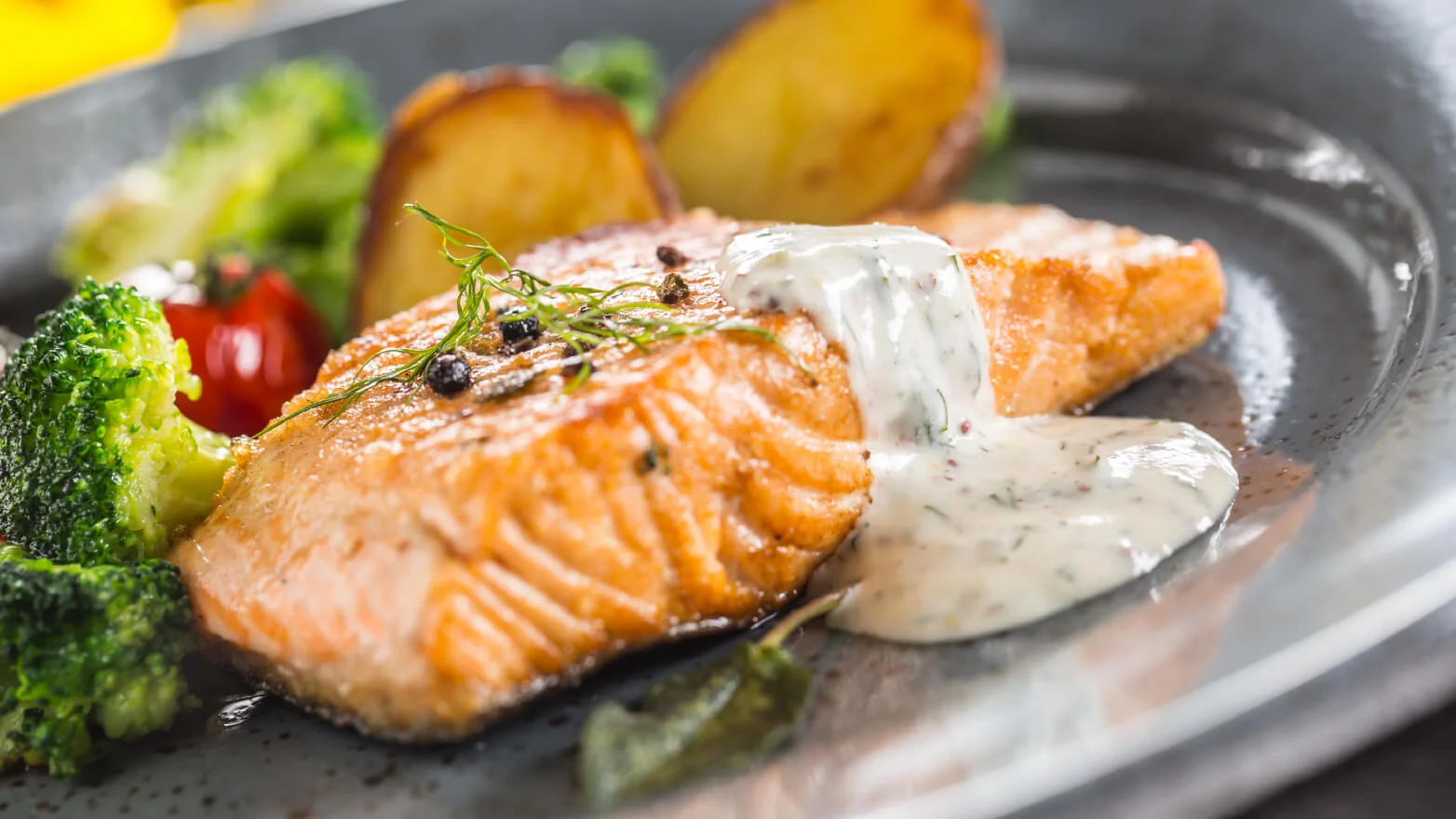 a photo of a salmon filet with dill sauce