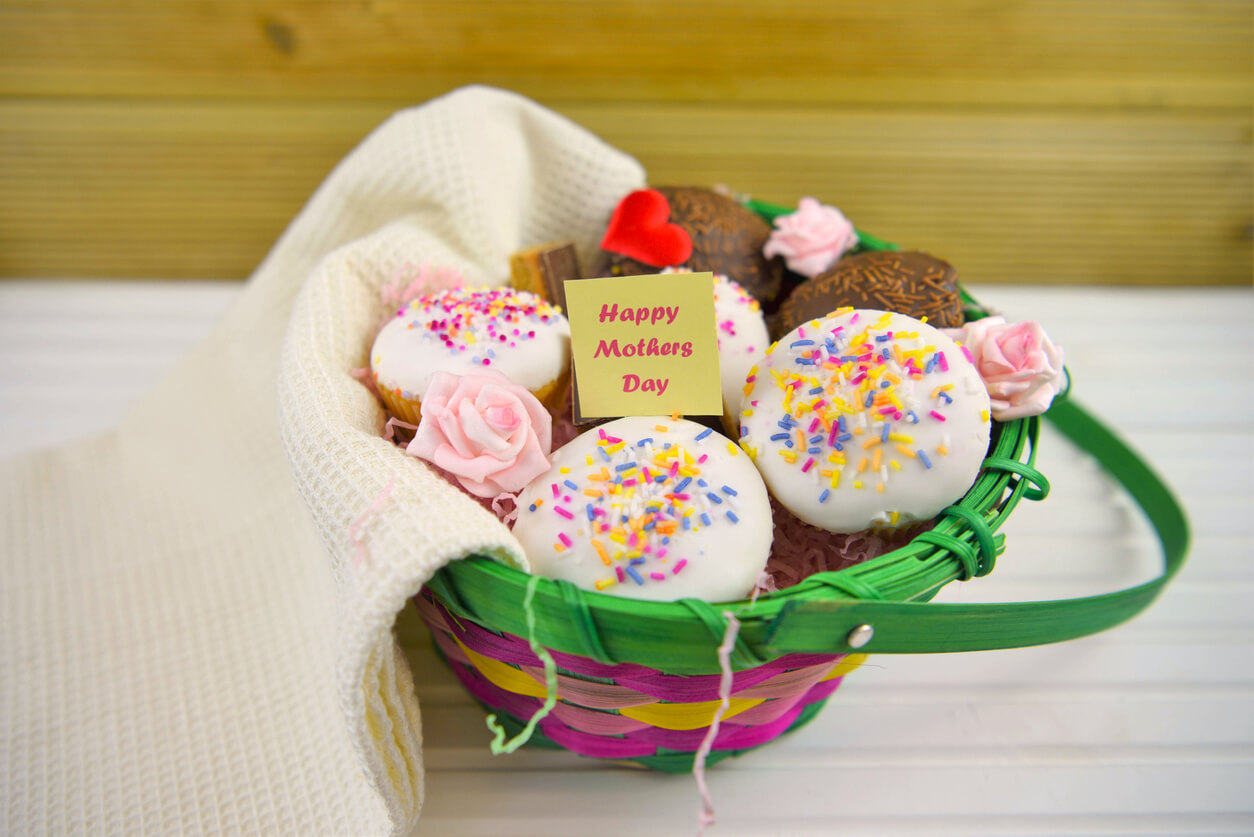 mothers day gift basket of mini cakes chocolate and flowers