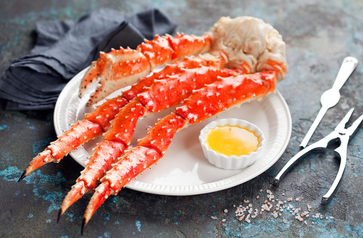 Red king crab legs with butter sauce on a plate