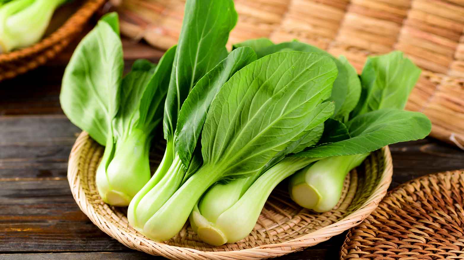 A pile of bok choy in a woven bowl