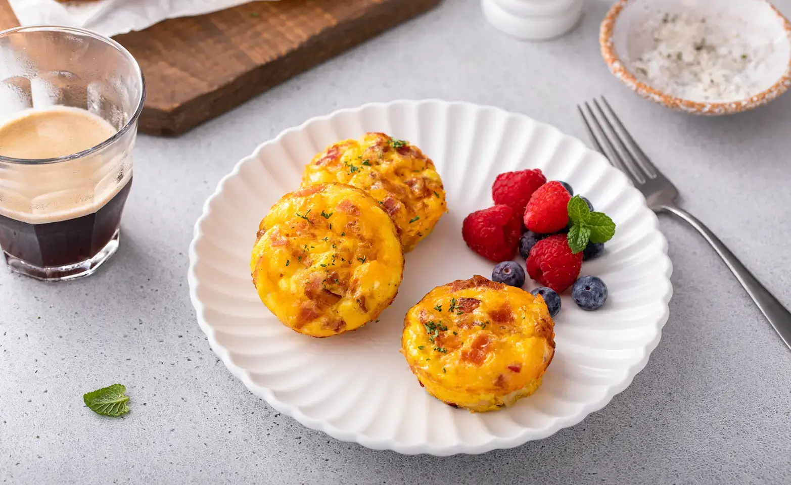 Keto egg muffins on a white plate with berries