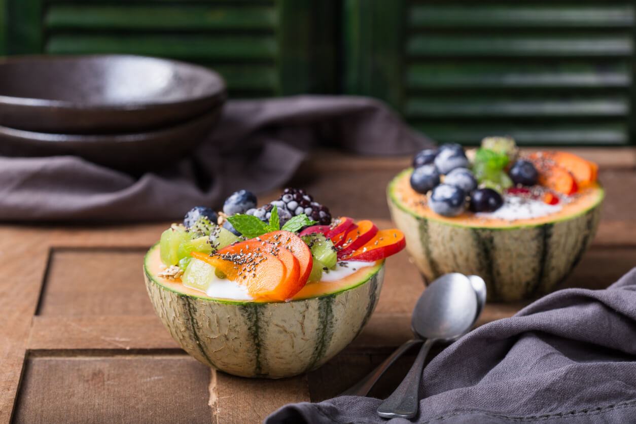 Fruit salad with yogurt in carved melon cantaloupe bowl