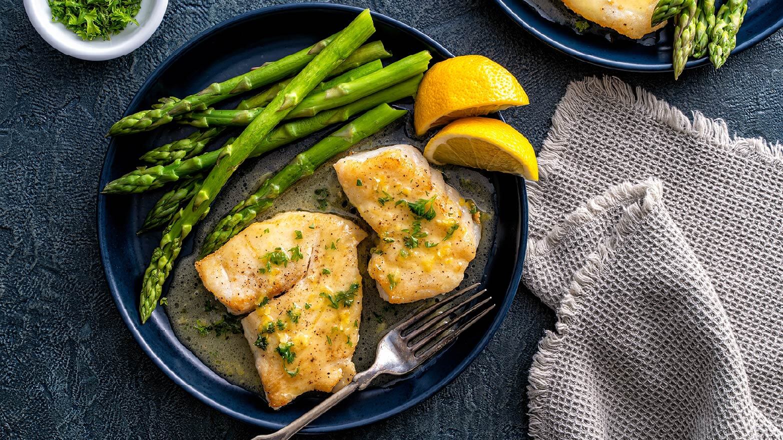 Baked halibut with lemon, herbs and asparagus.