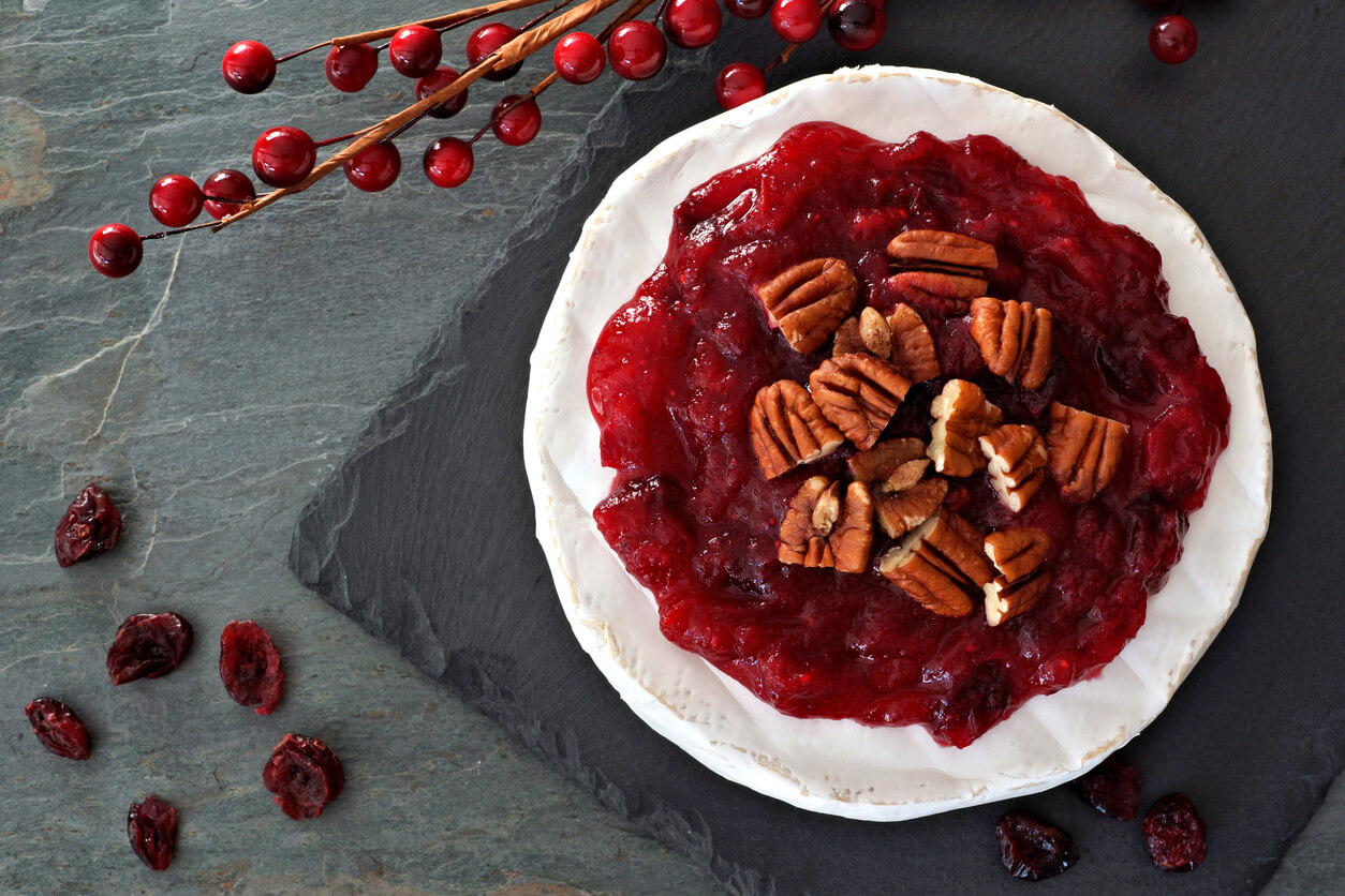 Brie topped with cranberries and pecans, above view on slate