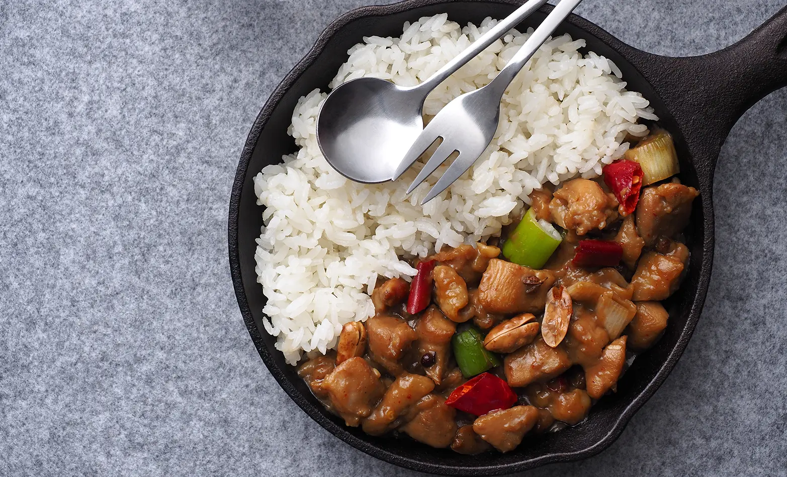 A skillet of kung pao chicken with rice