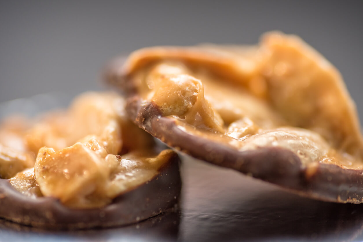closeup view of two almond nuts covered with chocolate and toffee