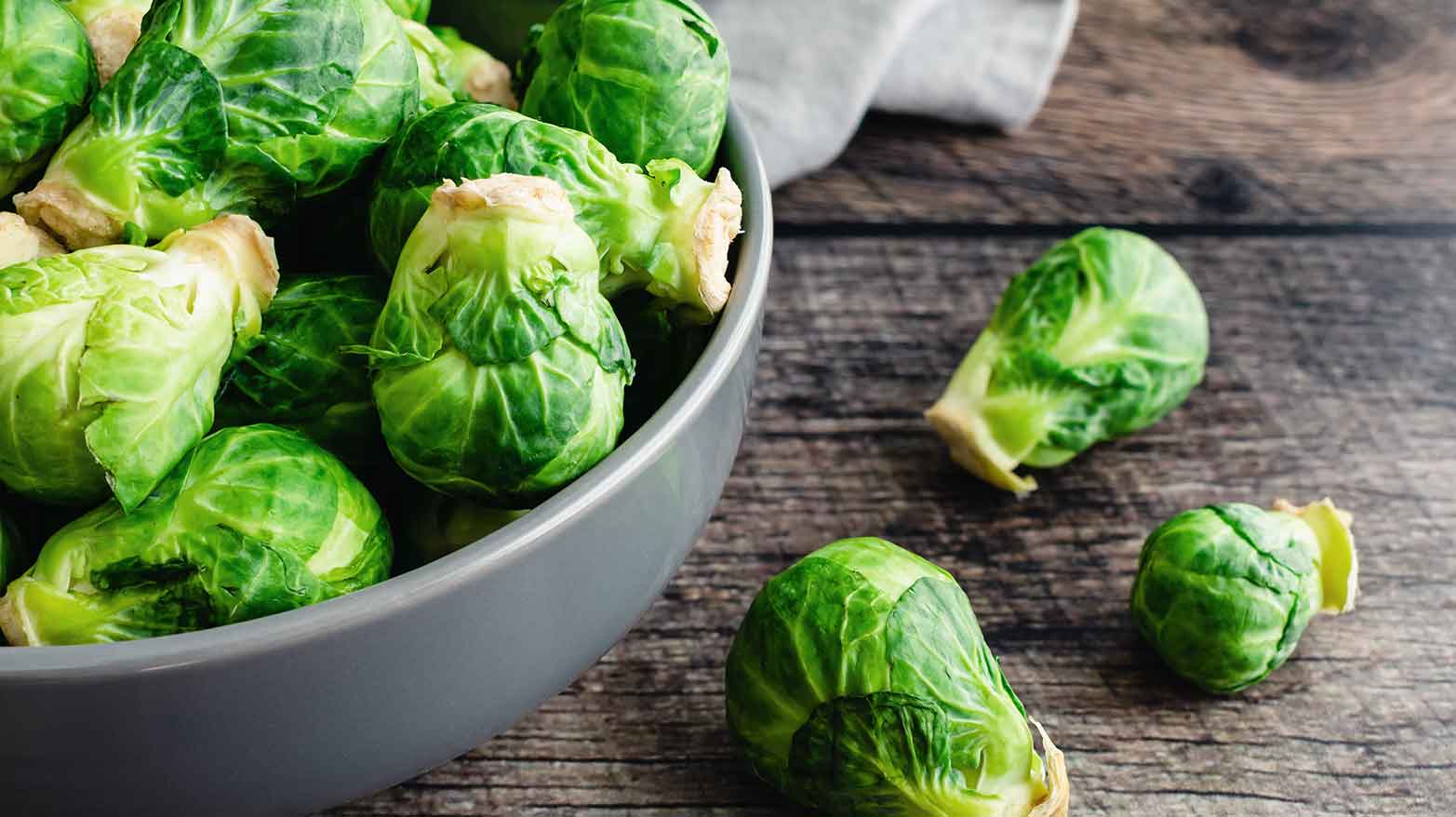 Brussels sprouts in a gray bowl on a wooden table