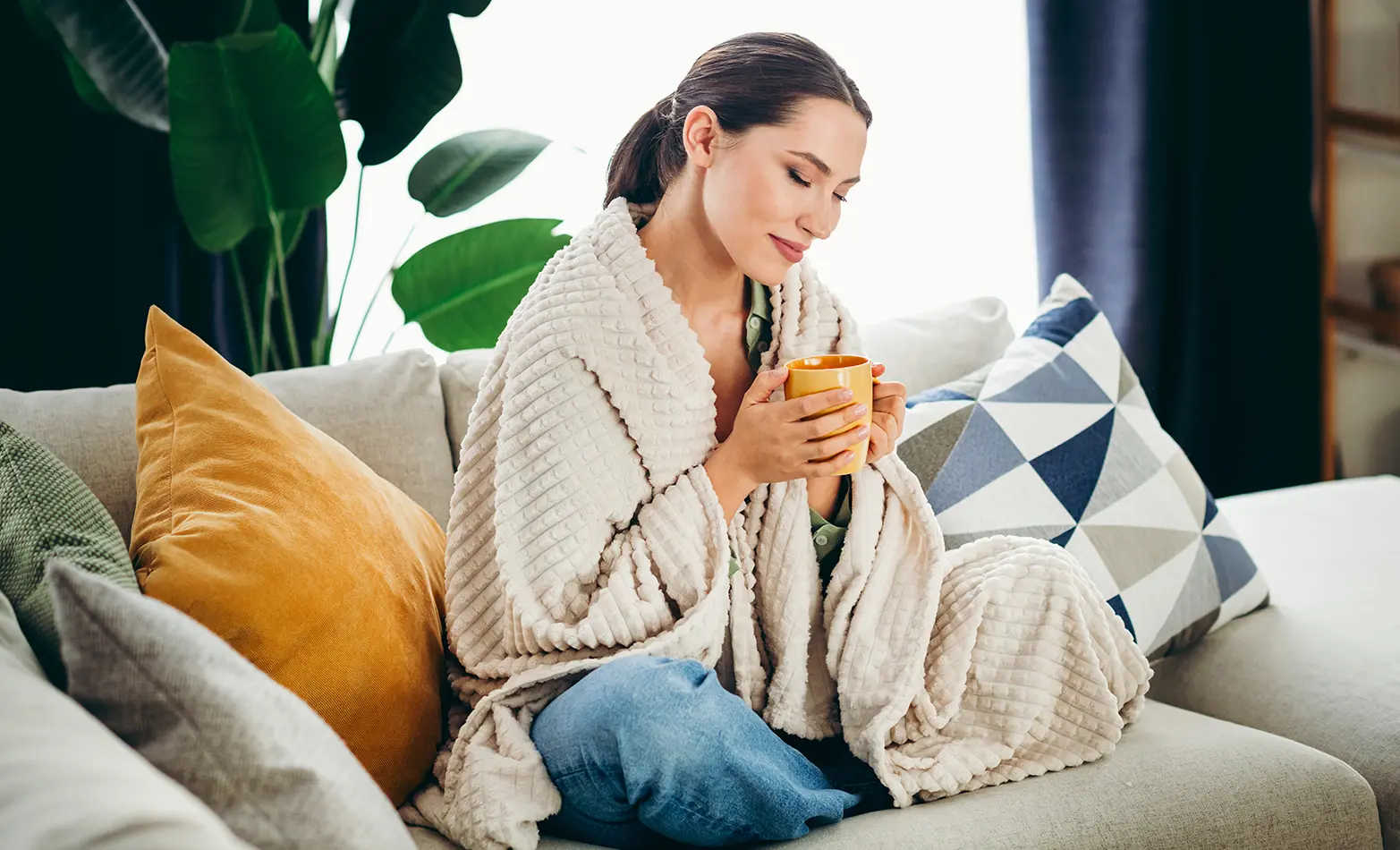A photo of a woman with a warm throw blanket.