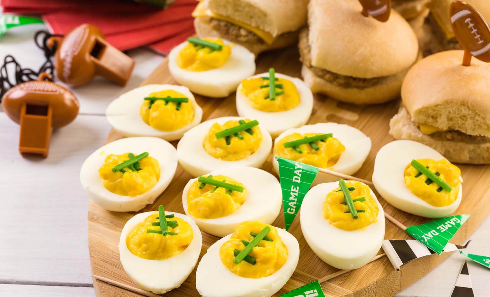 football-themed deviled eggs on a wooden serving board