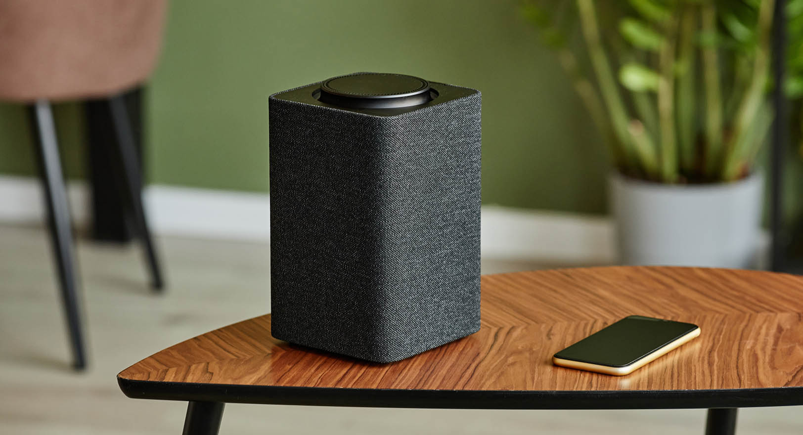 A photo of a small black speaker on a side table.