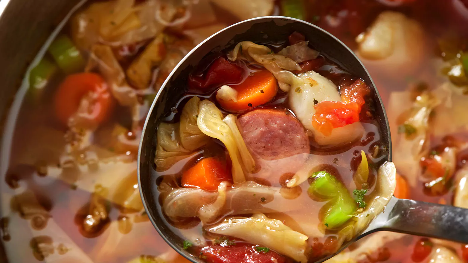 A close-up on a spoonful of Kielbasa slow cooker soup.