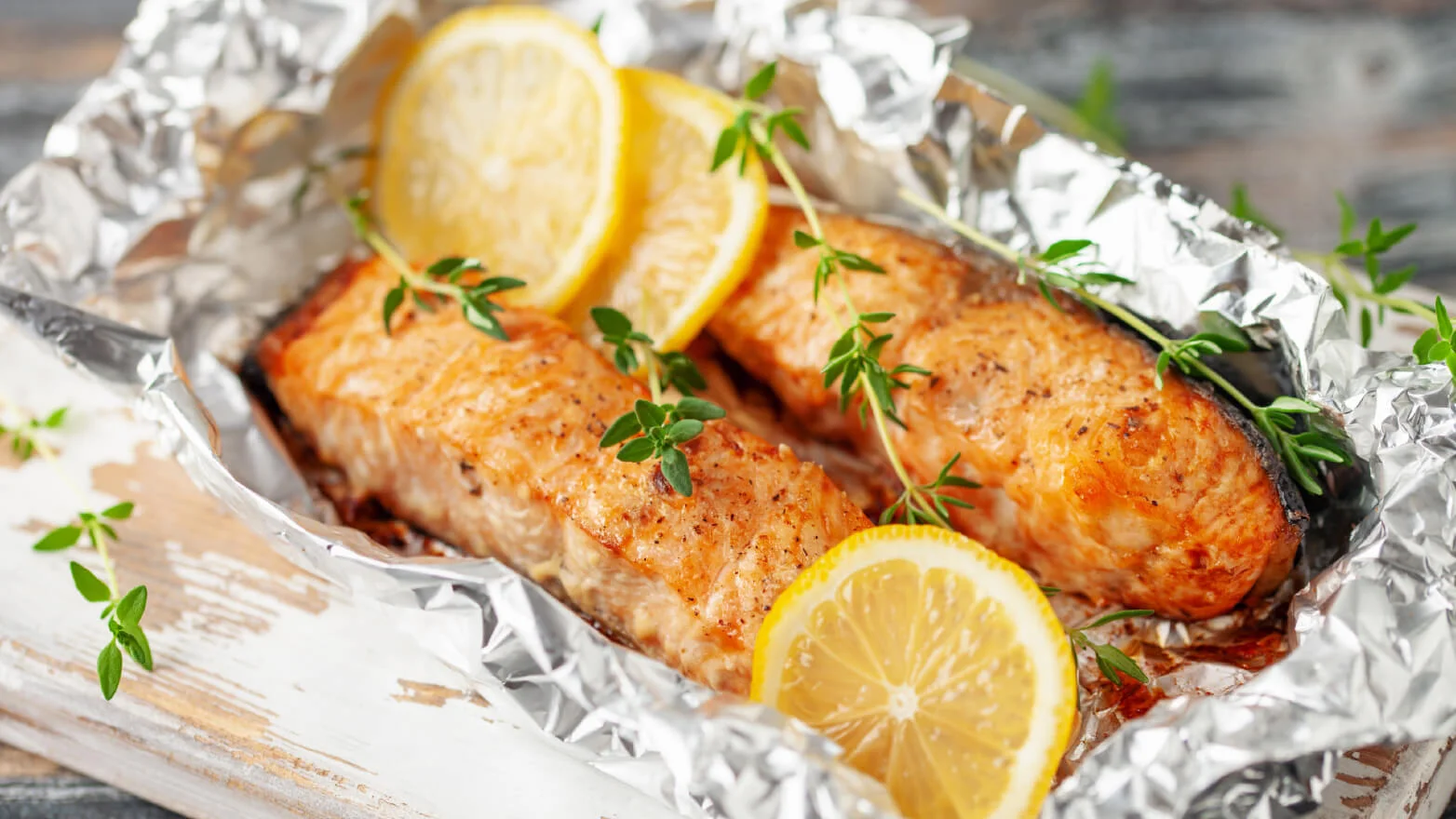 a photo of a grilled salmon foil packet with lemon slices