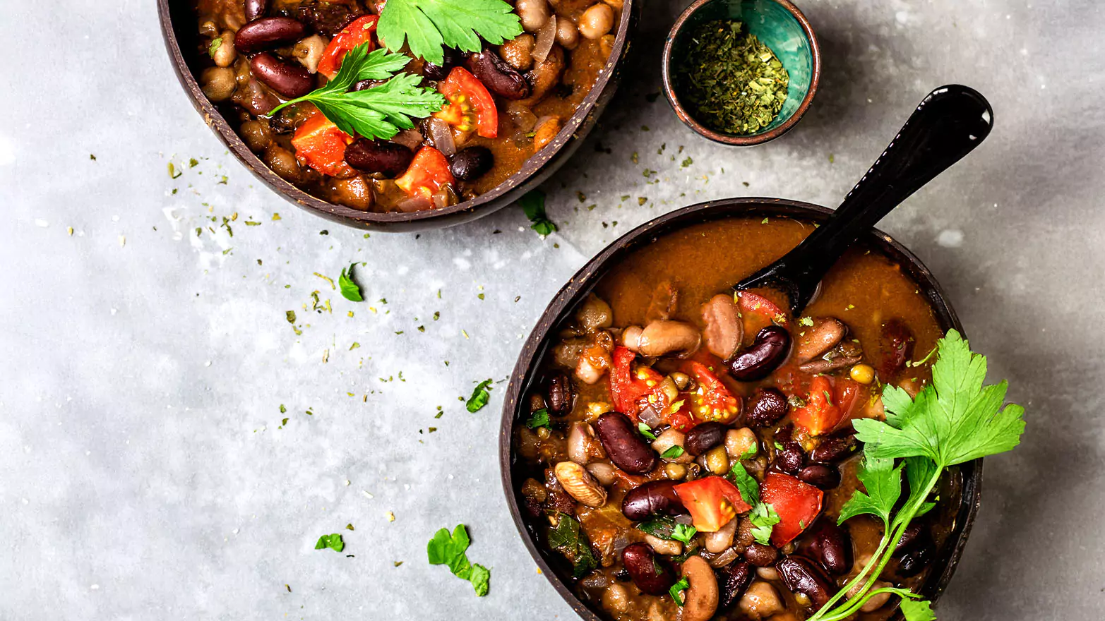 Two servings of black bean soup with garnish.