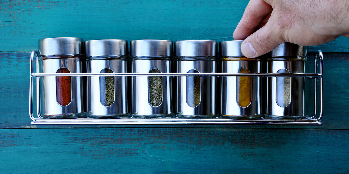 Chef hand returning spice into a spice rack