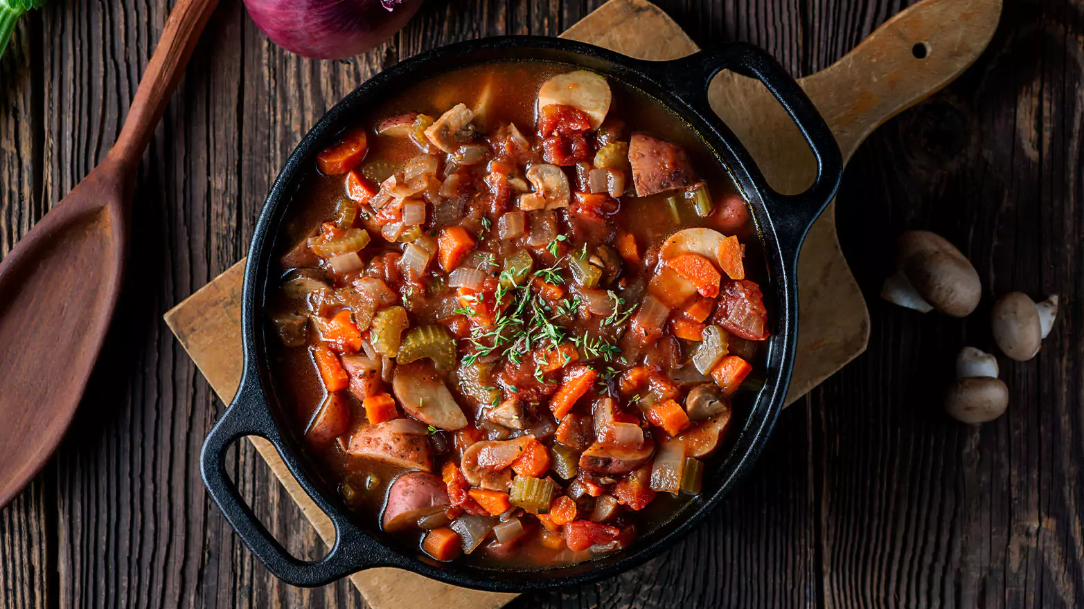 A bowl of vegetable soup served with bread.