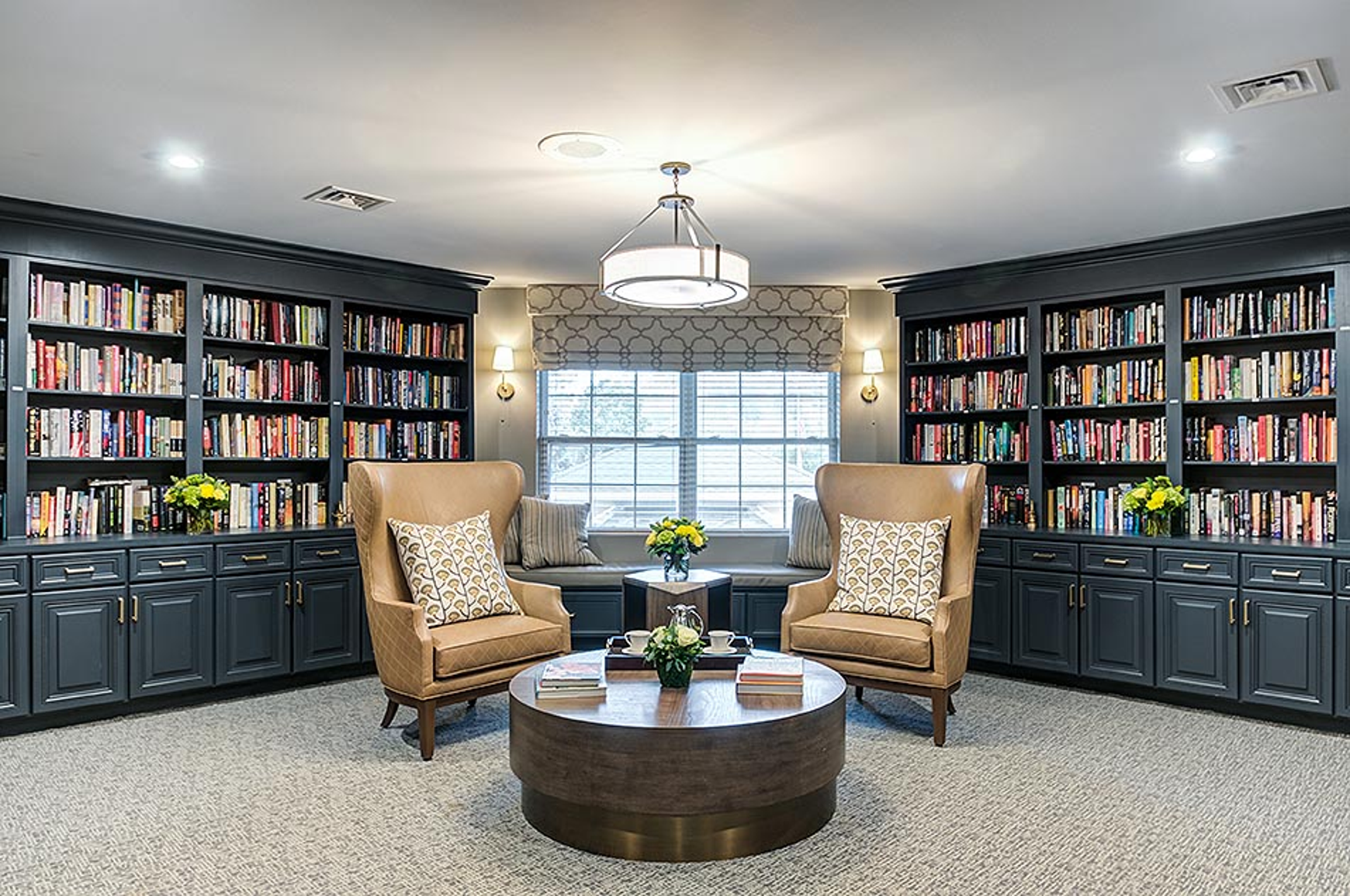 Library with built ins filled with wide selection of books and comfortable seating