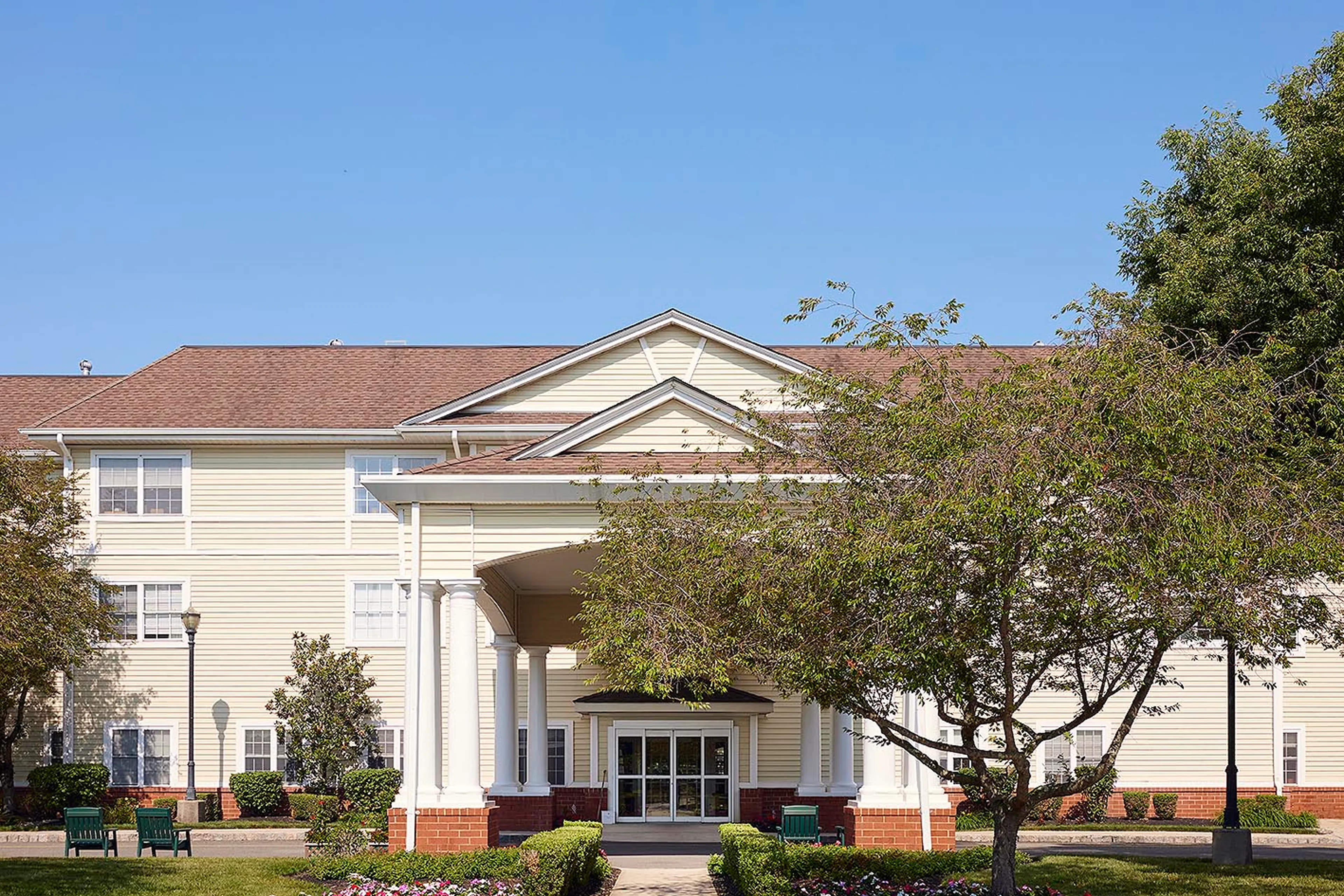 A stately entrance with benches and a portico