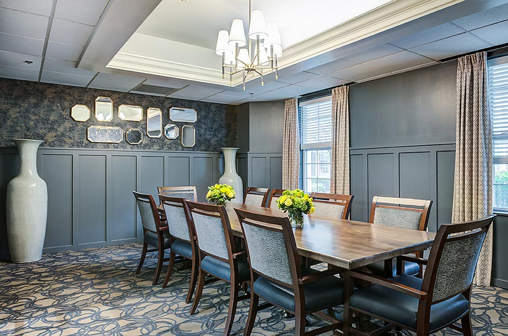 Private dining room with long table and chairs and wainscoting wall treatment