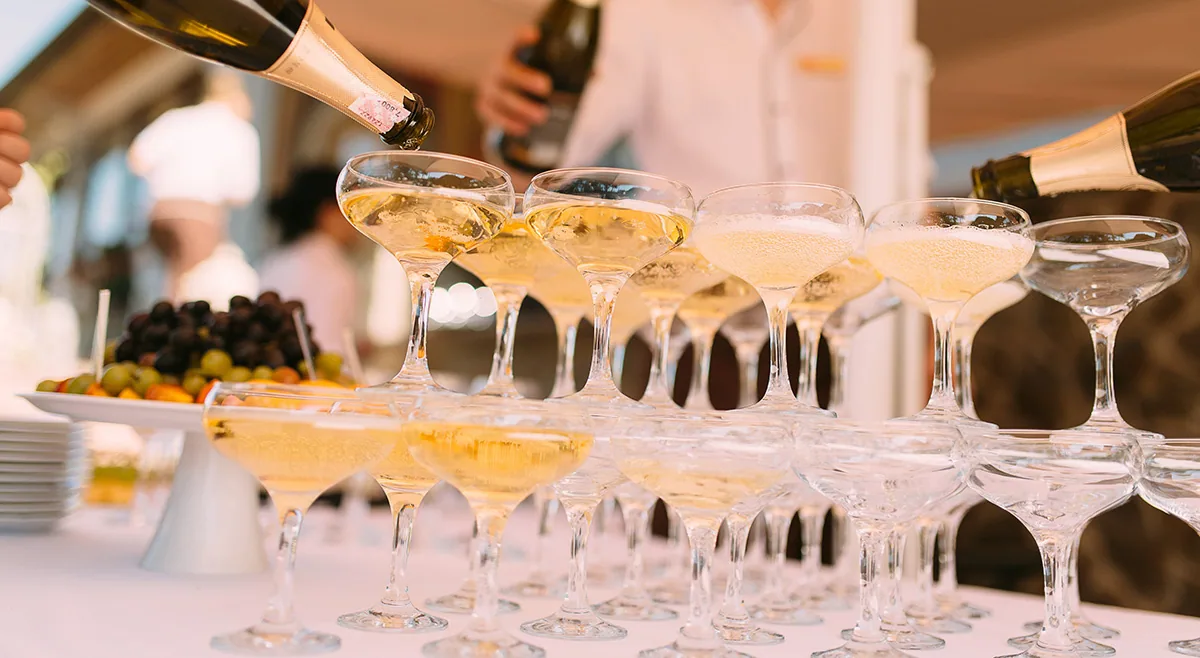 Hand puring champagne into glasses during a wedding