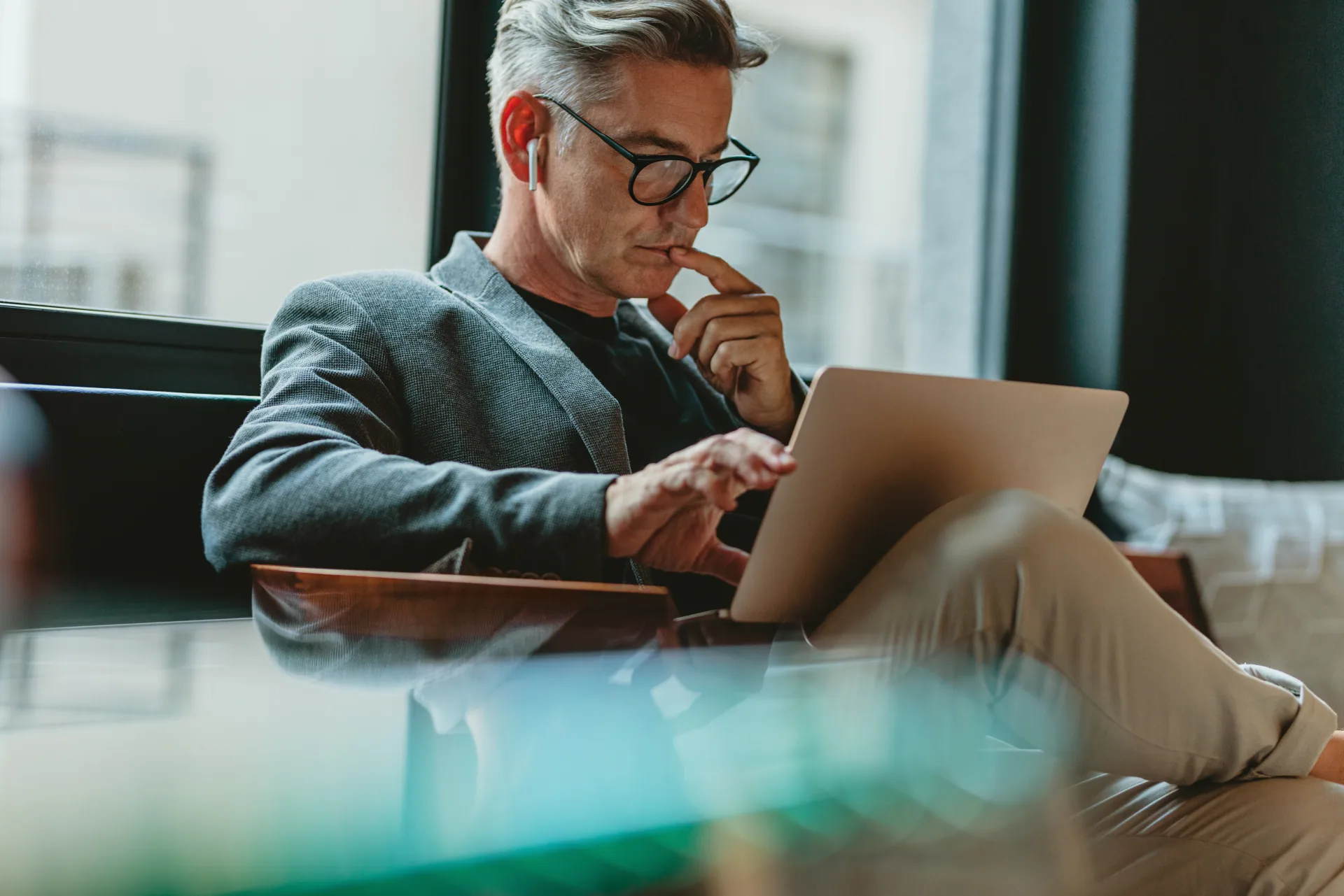 Man thinking about the pitfalls of AI and language learning while working on his laptop