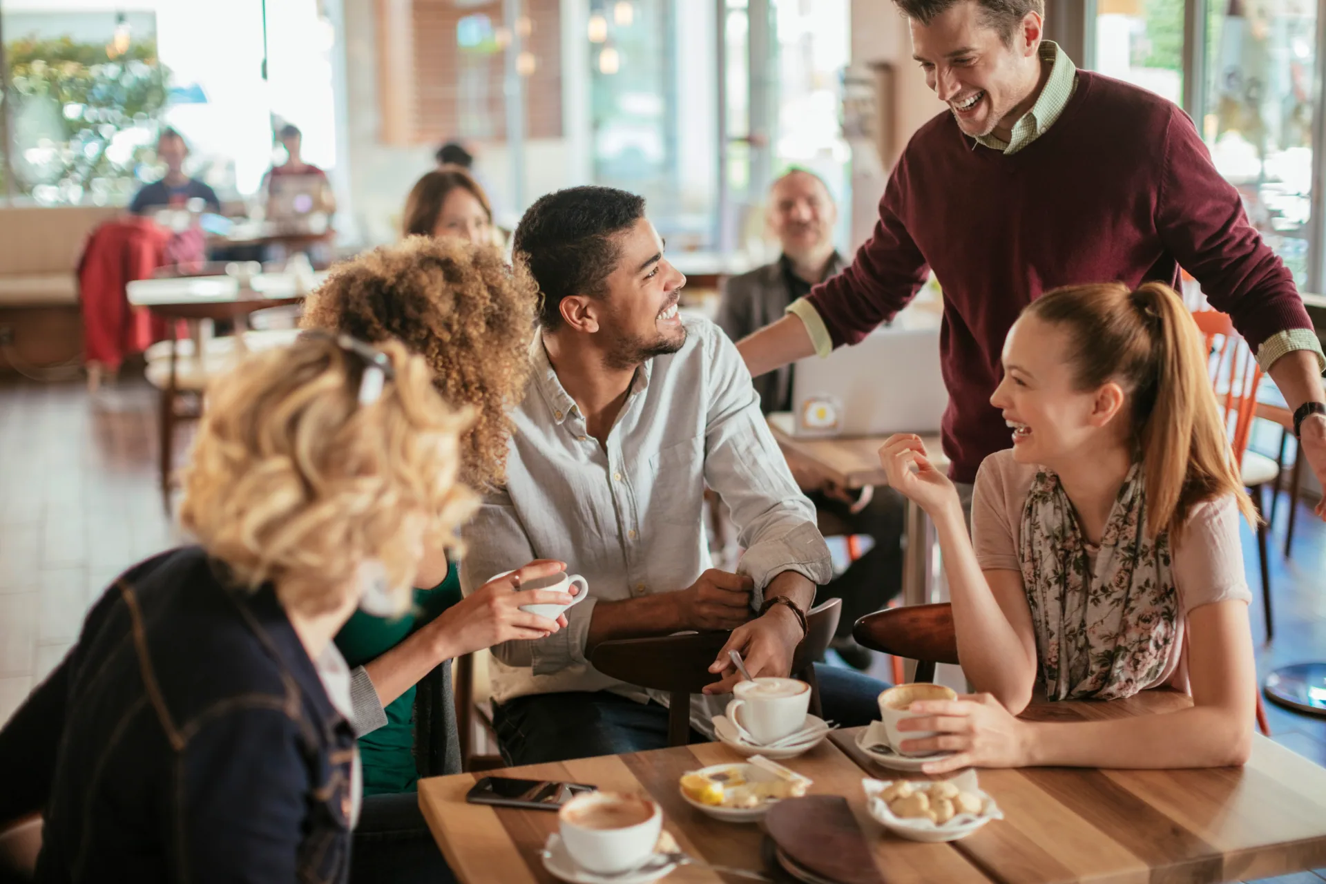 Friend group in a coffee shop talking about coffee