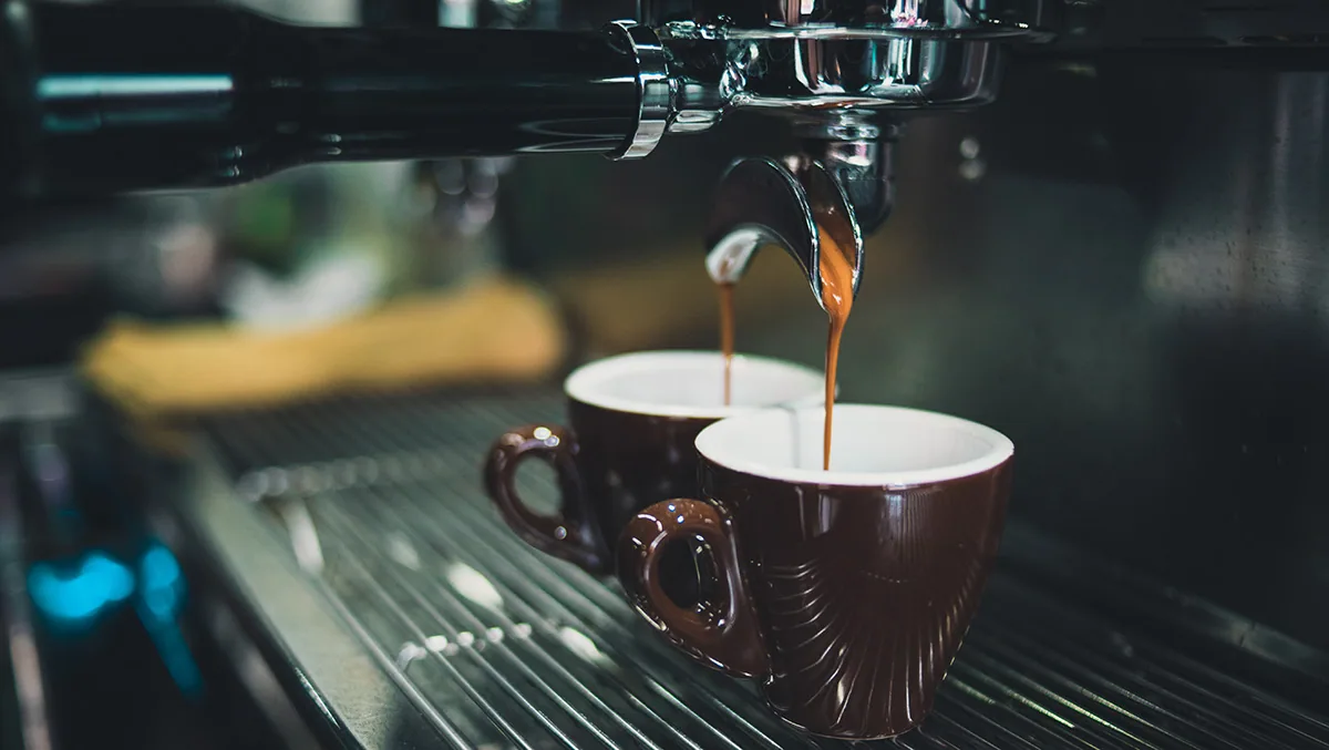 Coffee machine pouring espresso into tiny cups