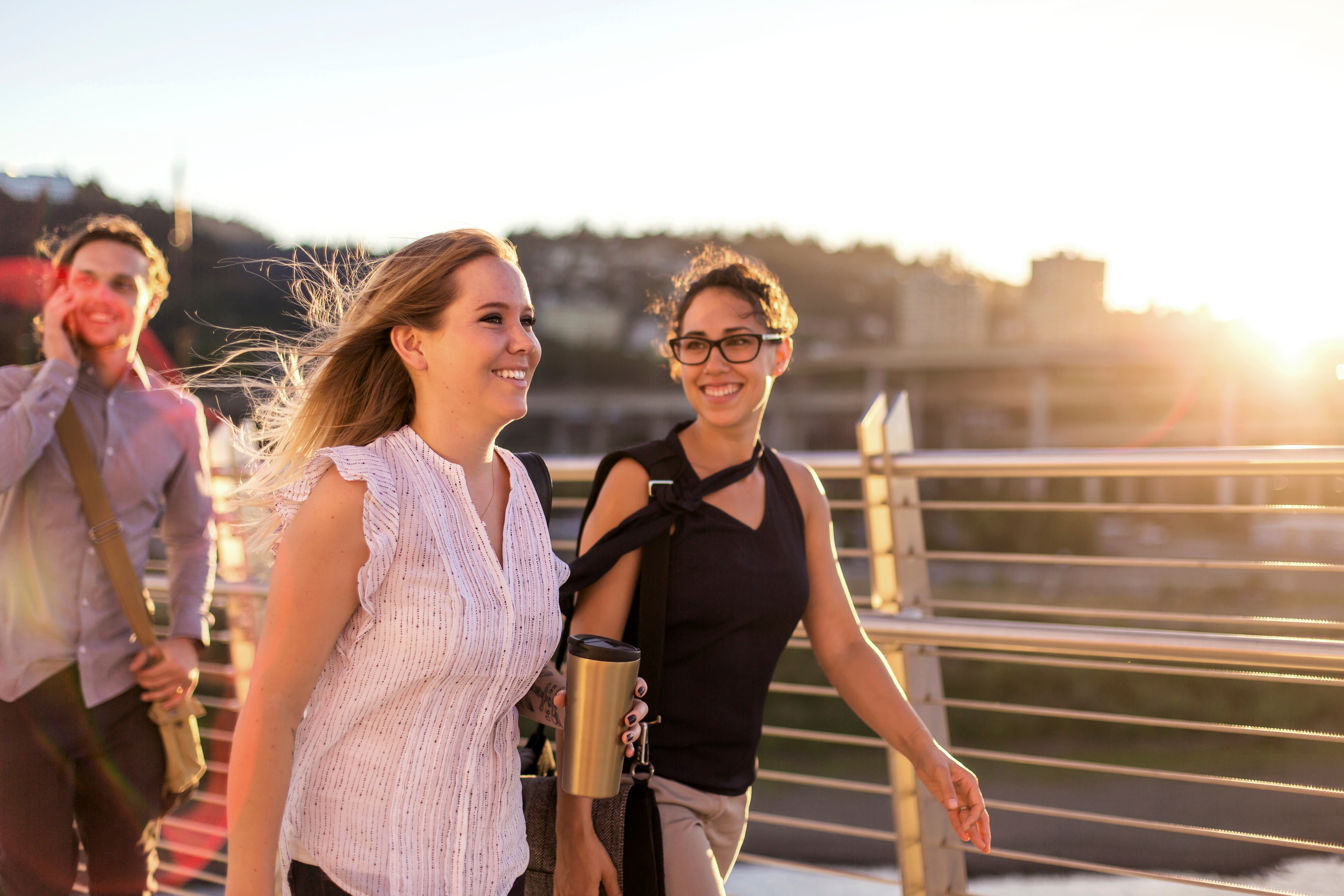 Two women chatting about the similarities between German and English while walking on a bridge