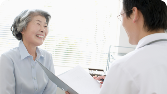 An Asian lady smiling at her doctor in a medical office