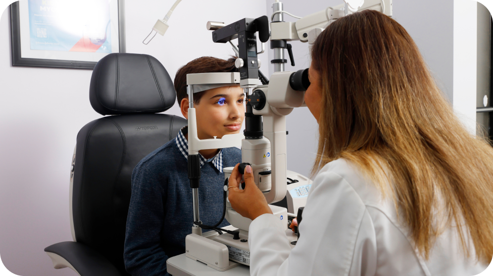 Ophtalmologiste examinant un jeune garçon sous une machine