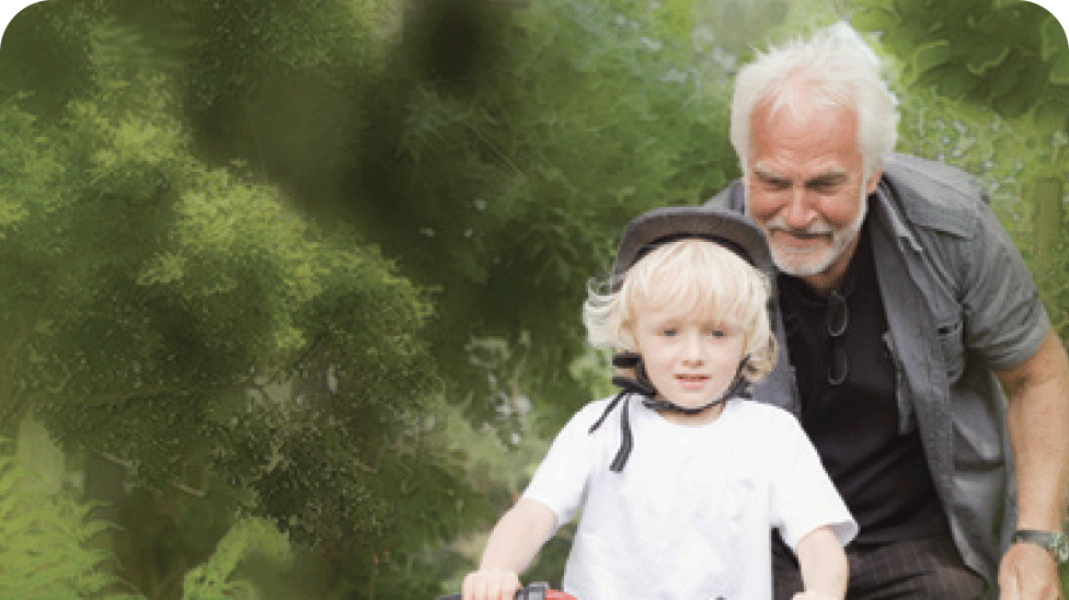 Grand-père apprenant à son petit-enfant à faire du vélo