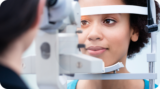 A doctor performing an eye test on a Black woman