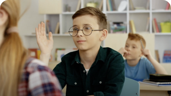 Child with glasses raising hand