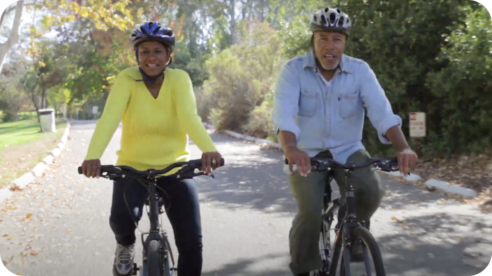 Two people happily biking in a park
