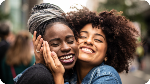 Two Black women happy and embracing each other
