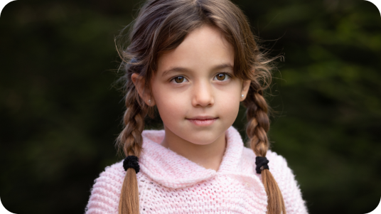 Young girl with pig tails in a pink polo shirt