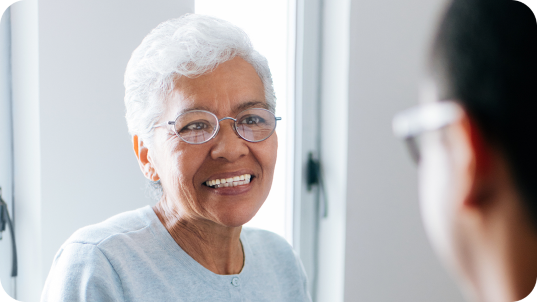 Grey haired lady wearing glasses and smiling