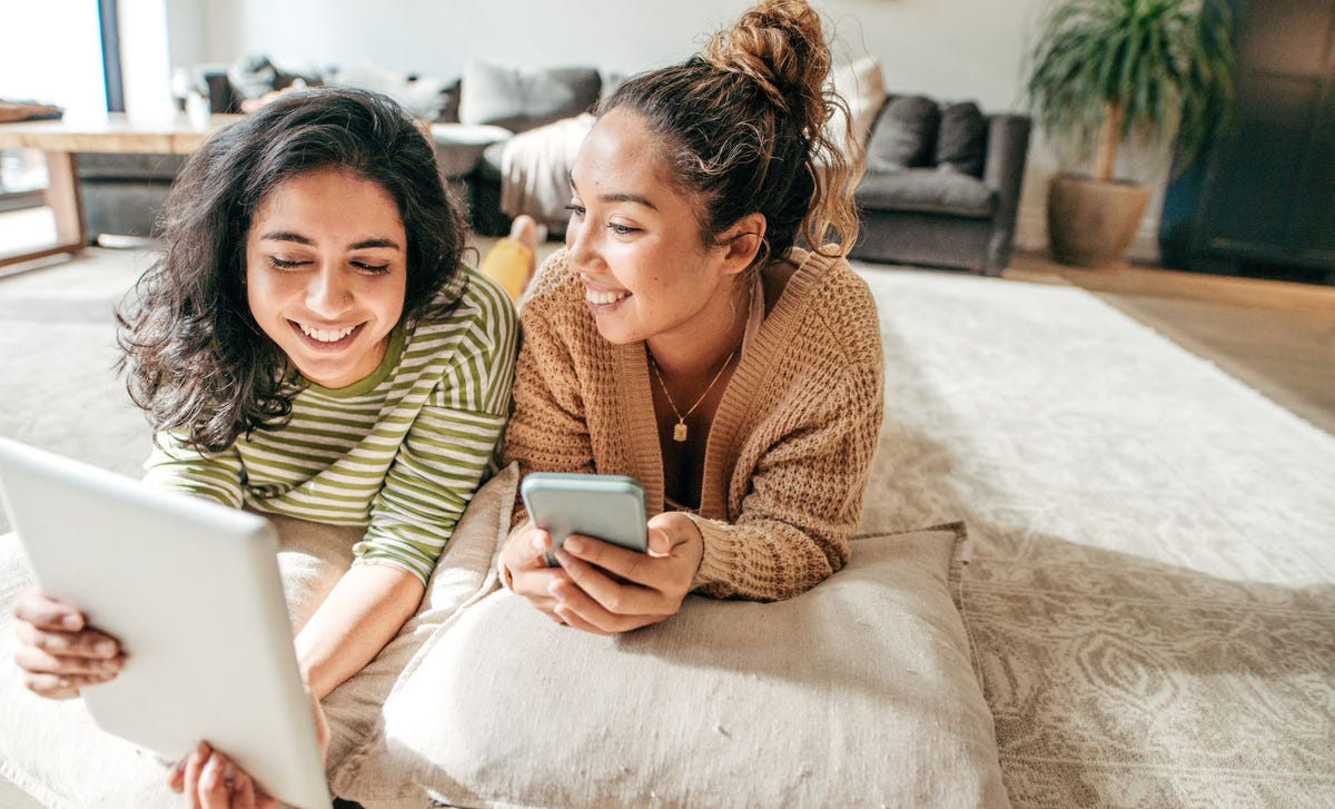 Women in a living room attending an online language course with Berlitz El Salvador from a laptop