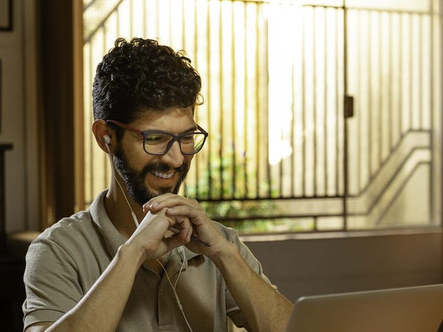Man in front of a laptop attending an online language class with Berlitz El Salvador