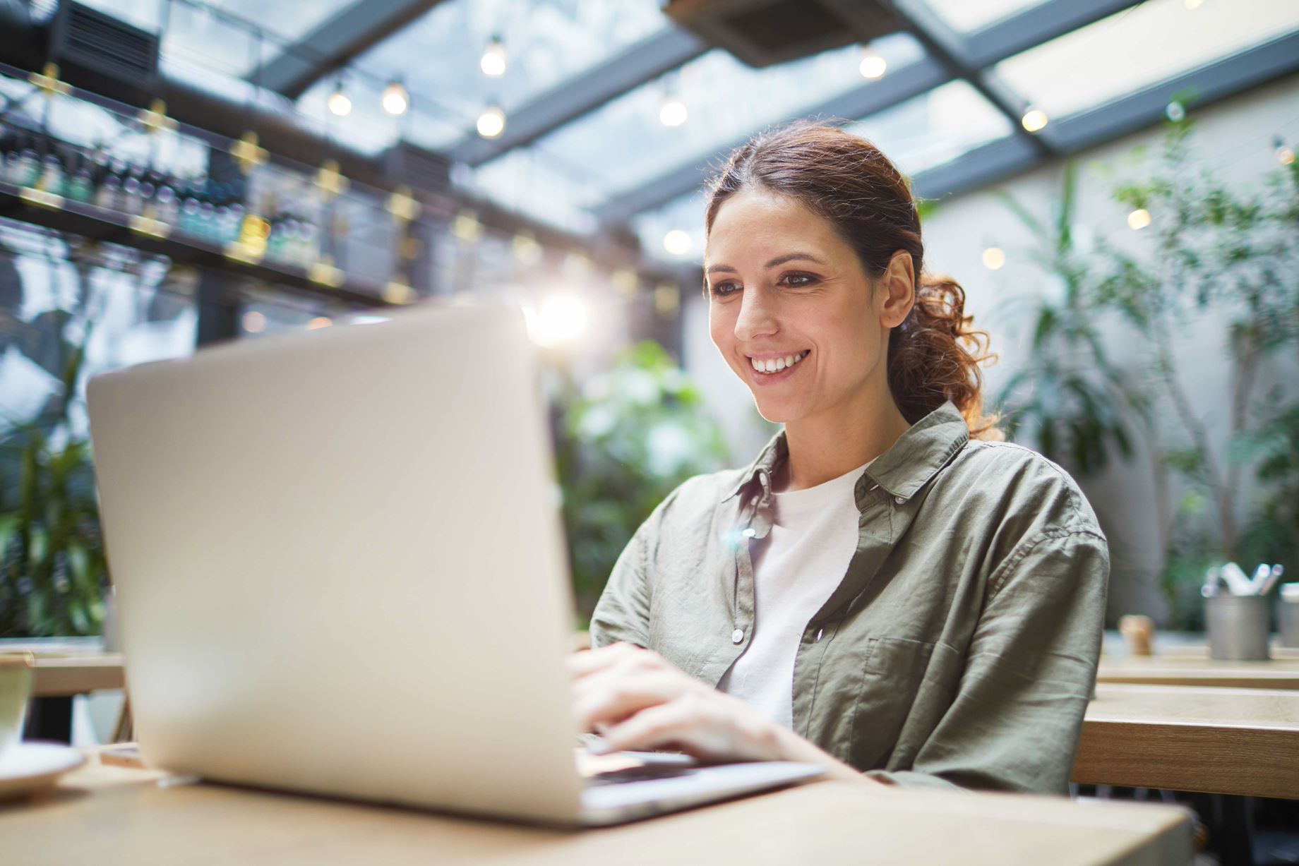 Woman sitting in front of a laptop and attending and learning a language online with Berlitz El Salvador