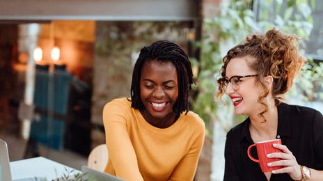 Women in front of their laptops drinking coffee and learning a new language online with Berlitz El Salvador