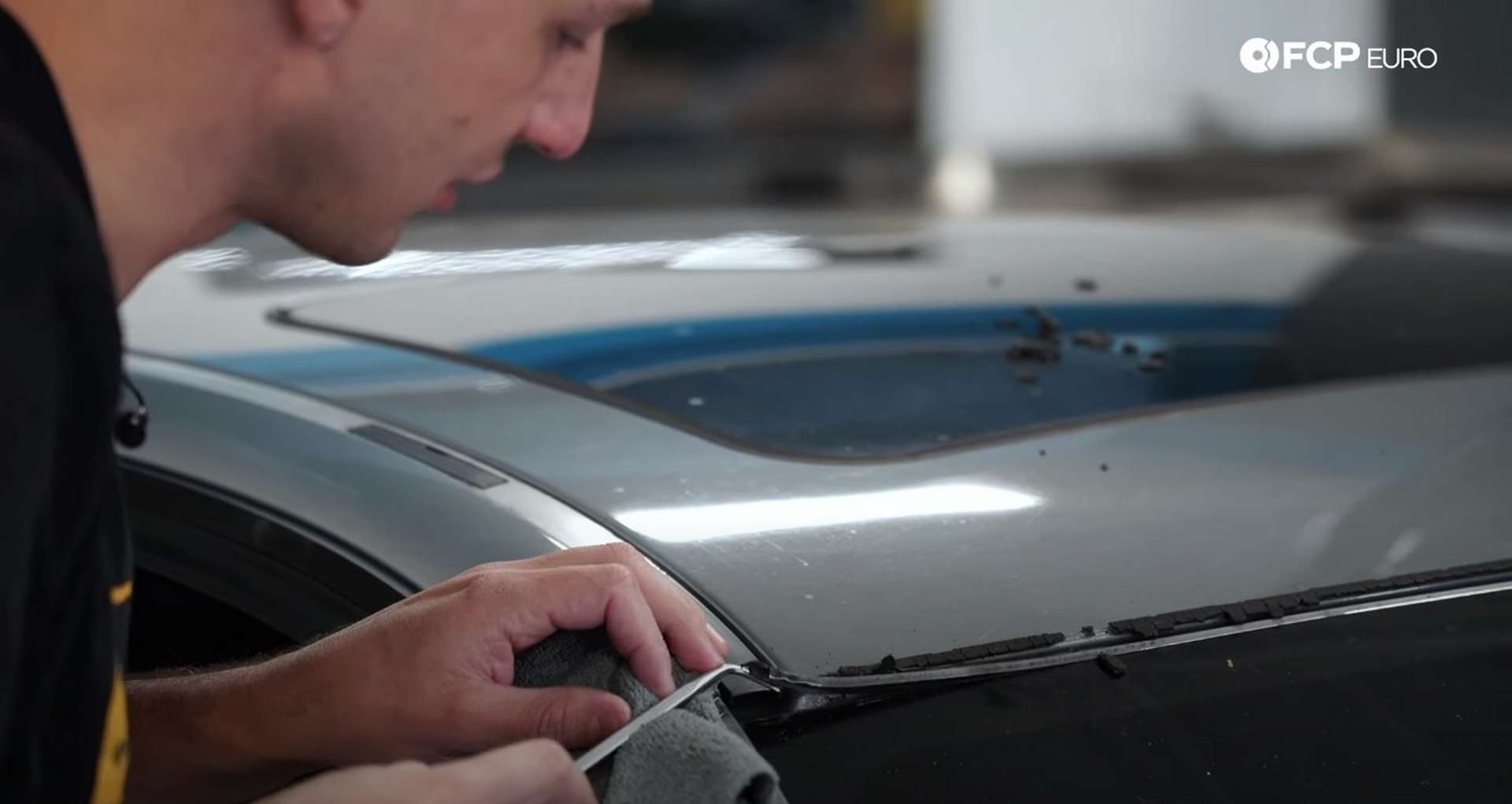DIY BMW E9X Windshield Replacement lifting the corner of the metal strip