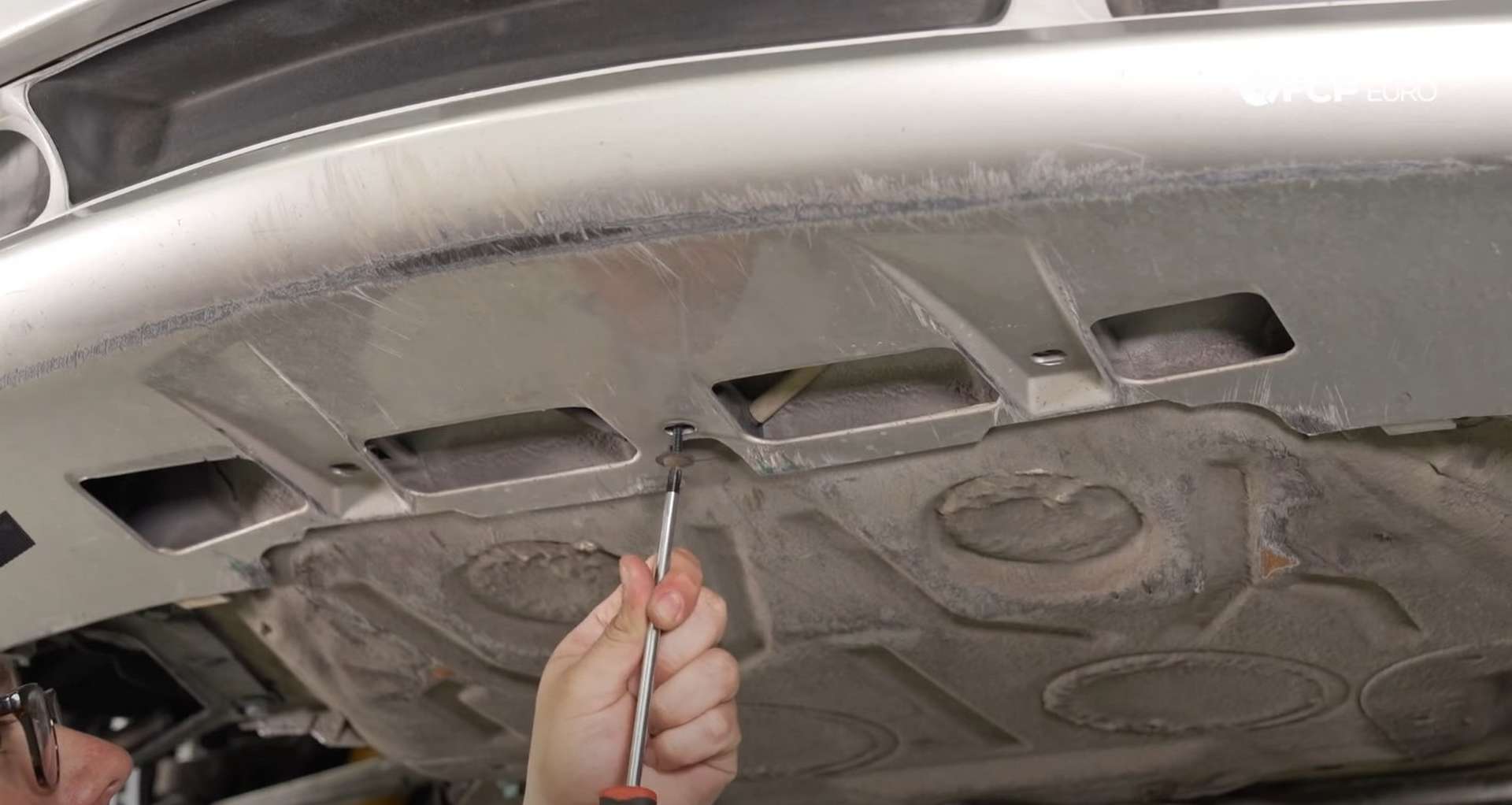 DIY Porsche 996 Radiator Replacement securing the bottom of the bumper cover