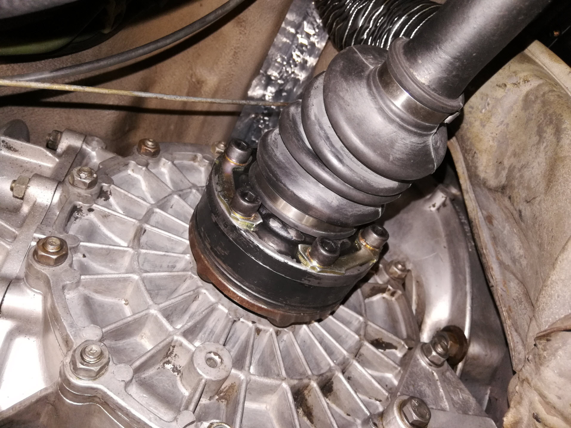 Air-cooled Porsche 911 inner CV joint with mounting hardware.