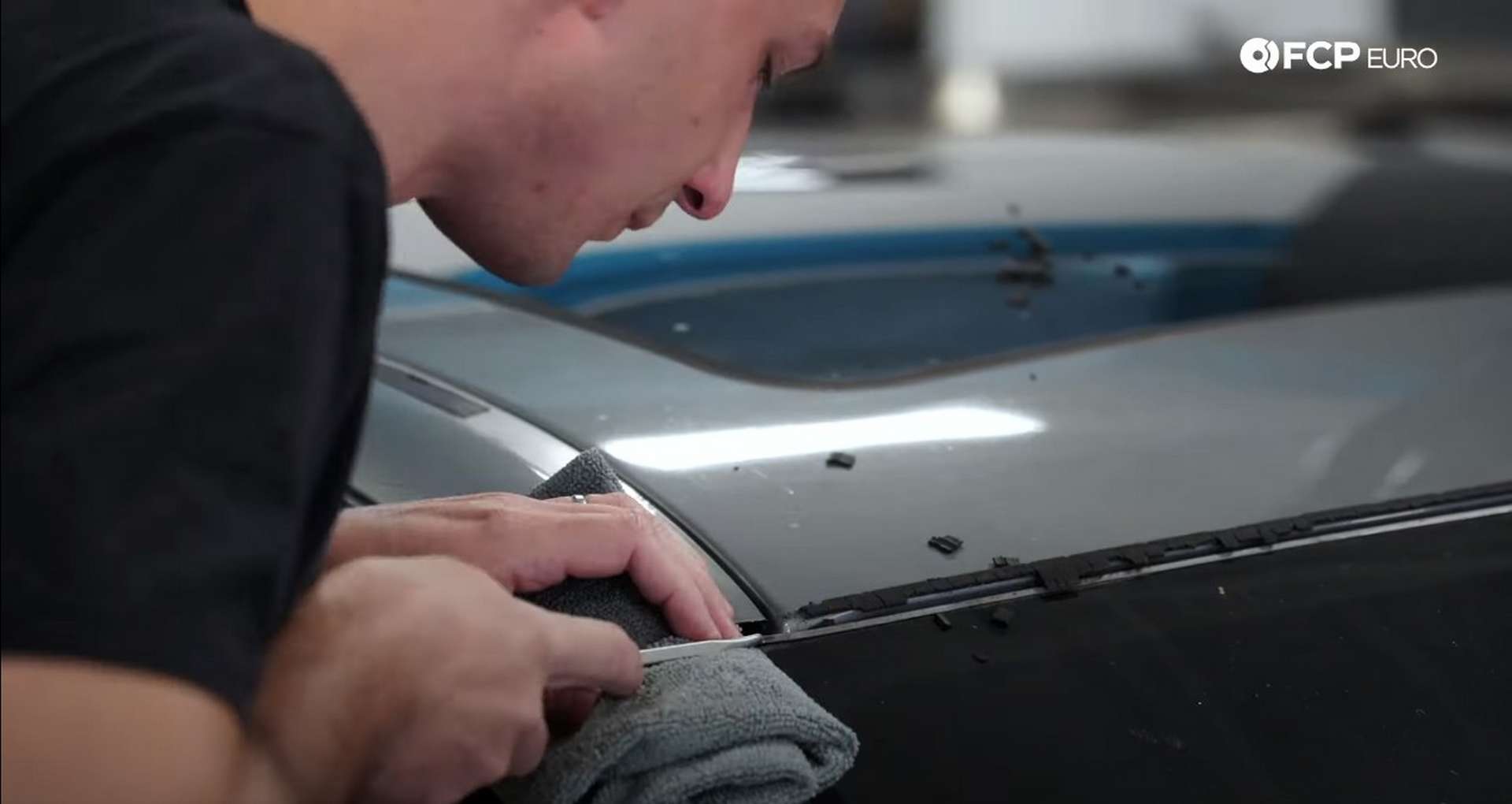 DIY BMW E9X Windshield Replacement lifting the corner of the metal strip