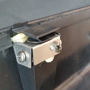 Plastic car fastener sitting in repaired metal and plastic housing. 