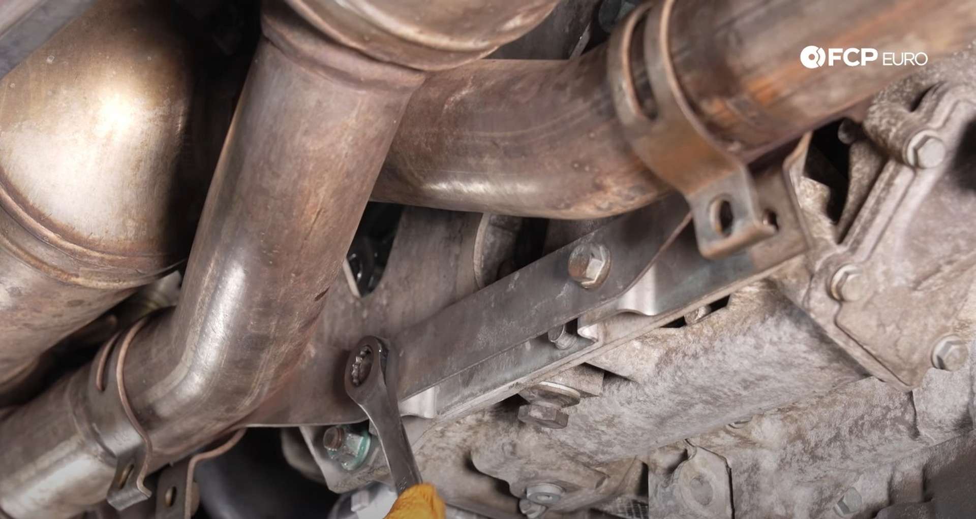 DIY Porsche 996 911 Water Pump And Thermostat Replacement tightening the exhaust bracket’s bolts