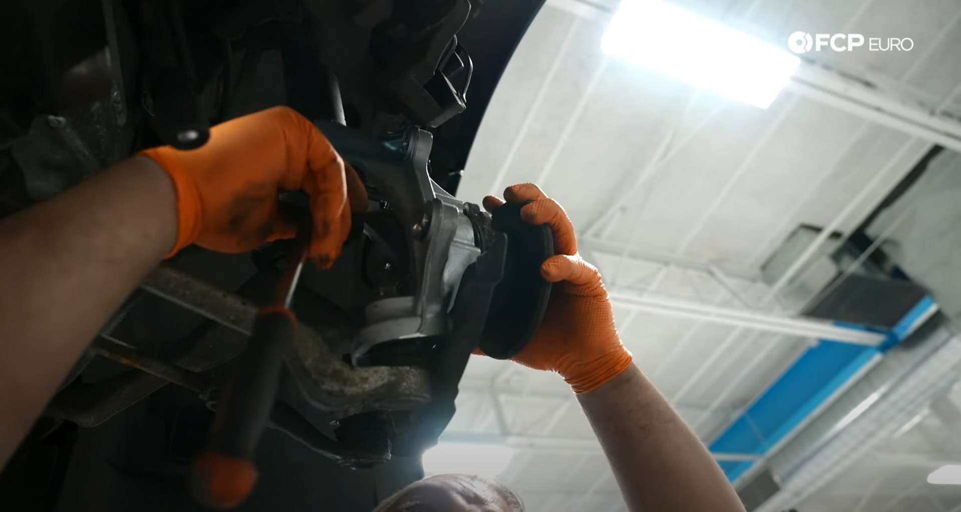 DIY BMW E9X Wheel Bearing Replacement holding the hub while removing the final bolt